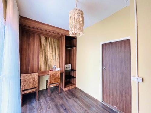 a dining room with a table and a chandelier at U're Holitel in Haad Rin