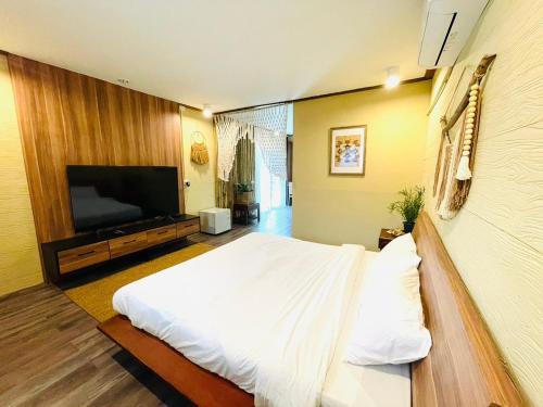 a bedroom with a bed and a flat screen tv at U're Holitel in Haad Rin
