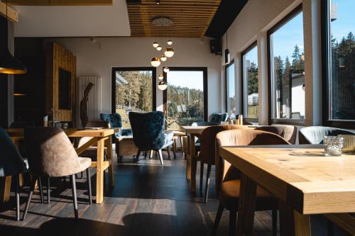 a restaurant with wooden tables and chairs and windows at VogtlandCAMPING in Markneukirchen