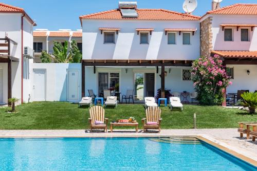 a villa with a swimming pool and a house at Posidonia Luxury Villas Kolympia in Kolimbia
