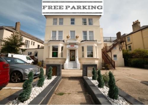 a white building with a sign that reads free parking at OYO Eagle House Hotel, St Leonards Hastings in Hastings