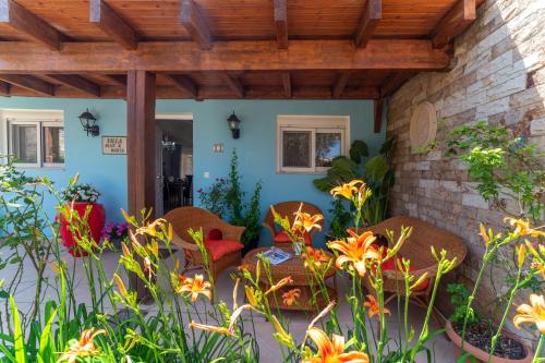 a patio with wicker chairs and flowers at Posidonia Luxury Villas Kolympia in Kolimbia