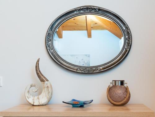 a mirror on a wall with vases on a shelf at Posidonia Luxury Villas Kolympia in Kolimbia