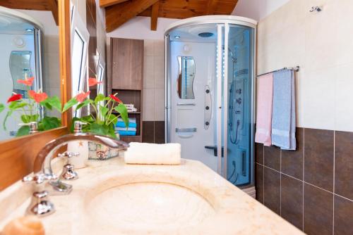 a bathroom with a sink and a blue shower at Posidonia Luxury Villas Kolympia in Kolimbia