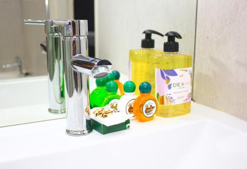 a bathroom counter with cleaning products and a mirror at Heroes Garden Lodge in Pietermaritzburg