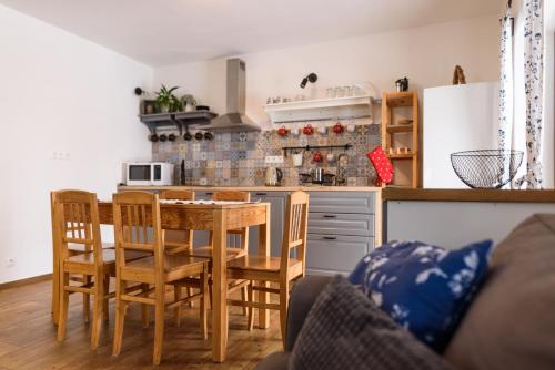 eine Küche mit einem Tisch und Stühlen sowie eine Küche mit einer Theke in der Unterkunft Apartmány Matěj in Dolní Morava