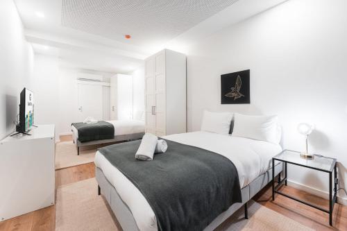 a bedroom with two beds and a television in it at GuestReady - Uptown suites in Porto