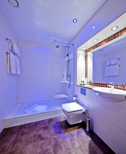 a bathroom with a tub and a toilet and a sink at Abbey Hotel Golf & Spa in Redditch