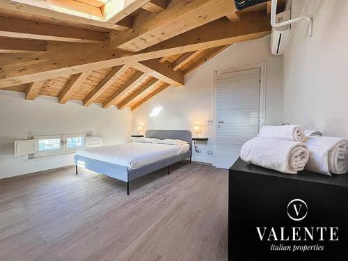 una grande camera da letto con un grande letto e soffitti in legno di Villa Valente - Apartments a Capannori