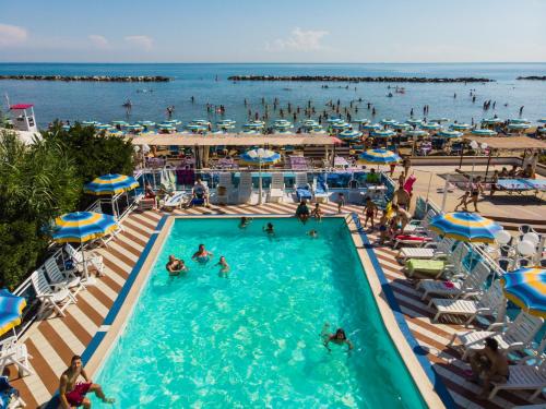 um grupo de pessoas em uma piscina em uma praia em Bikini Tropicana Family Hotel em Lido di Savio