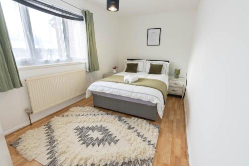 a bedroom with a bed and a rug at 3 Bedroom house with free parking, Dalstone,Aylesbury in Buckinghamshire