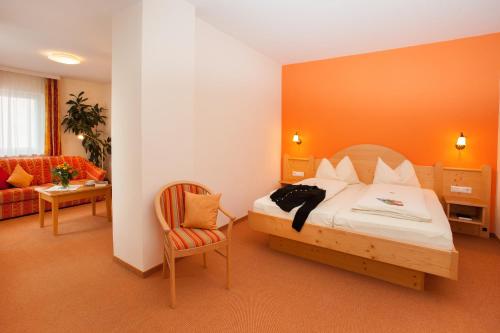 Habitación de hotel con cama y silla en Brauereigasthof Engel en Isny im Allgäu