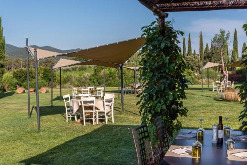a table and chairs under a canopy in a yard at Locanda dell'Aioncino in Bibbona