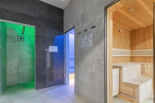 a bathroom with a shower and a glass door at Apartament Holiday 8/25 in Rewal