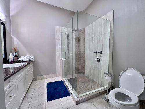 a bathroom with a shower with a toilet and a sink at Kia Oceanview Property in West Vancouver