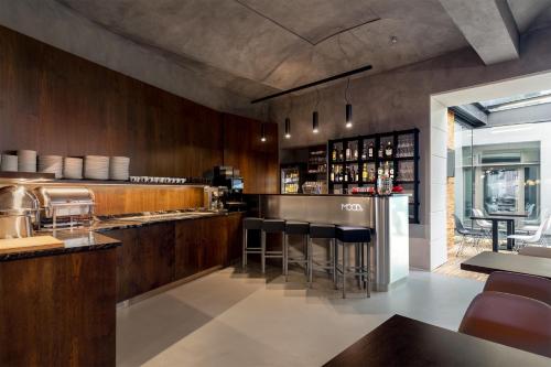 a kitchen with a bar with black stools at MOODs boutique hotel in Prague