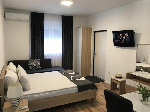 a bedroom with a bed and a tv on the wall at COMFORT APARTMENTS M&S in Mostar