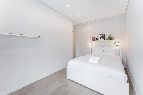 - une chambre blanche avec un lit blanc dans l'établissement GuestReady - Amazing stay near Cedofeita Church, à Porto