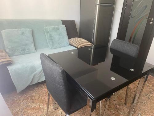a room with a desk and a couch with a table and chairs at Black&White Studio Ultracentral in Craiova