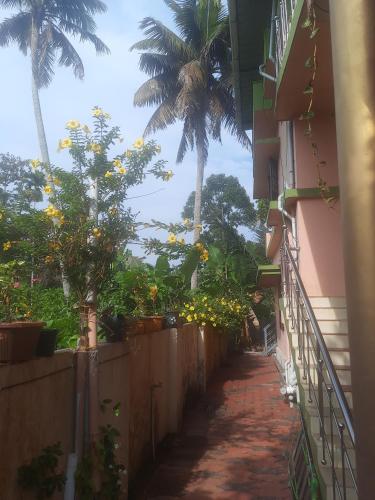 an alley with palm trees and a building at NAVENDU HOMESTAY in Alleppey