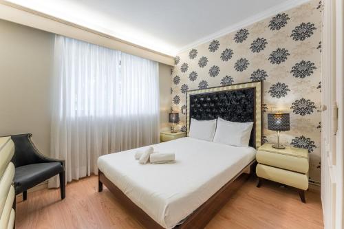 una camera da letto con un grande letto bianco e una sedia di Coastal escape in Lavra a Lavra