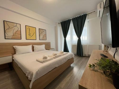 een slaapkamer met een bed en een flatscreen-tv bij Perfect Host Palas Centru in Iaşi