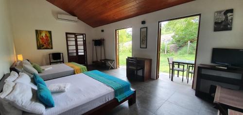 a bedroom with two beds and a flat screen tv at Ocean Cottage in Kalametiya