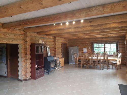 a living room with wooden walls and a table and chairs at Poilsio ir sveikatinimo sodyba Pušų Šlamesy in Vilnius