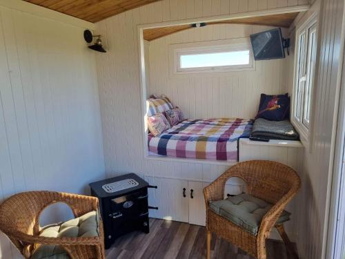 a small room with a bed and two chairs at North Muasdale Farm - Byre View in Muasdale