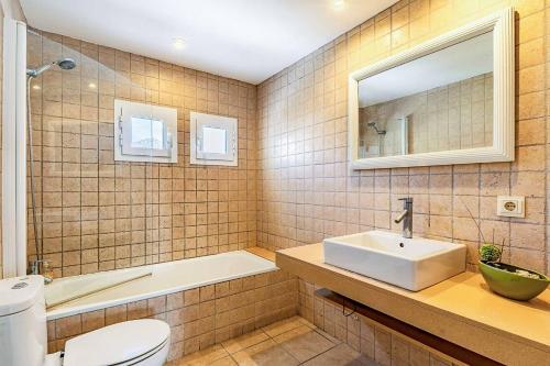 a bathroom with a sink and a tub and a toilet at Villa Monsy 1 in El Port