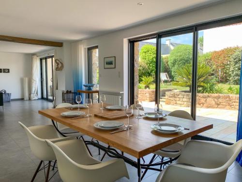 une salle à manger avec une table et des chaises en bois dans l'établissement Indigo - Maison les pieds dans l'eau à Damgan, à Damgan