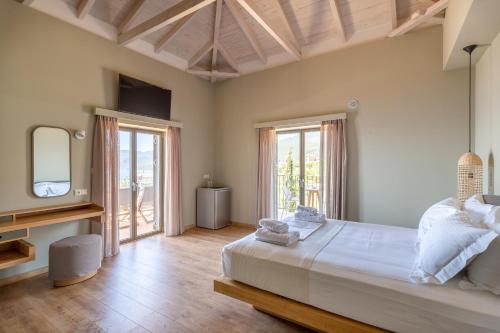 Diapori Suites Hotel في كارداميلي: غرفة نوم بسرير كبير وتلفزيون