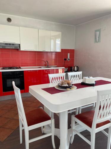 a kitchen with a white table and chairs and red cabinets at B&B SALERNO IN in Salerno