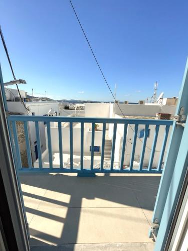 a balcony with a blue railing on a building at Lefteris in Mýkonos City