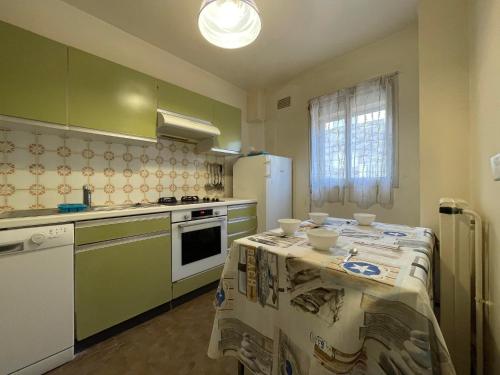 une cuisine avec des appareils verts et blancs et une table dans l'établissement 6BAT3 Appartement vue mer, à Collioure