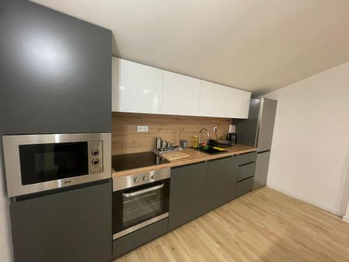 a kitchen with stainless steel appliances and white cabinets at Apartment My Choice in Sarajevo