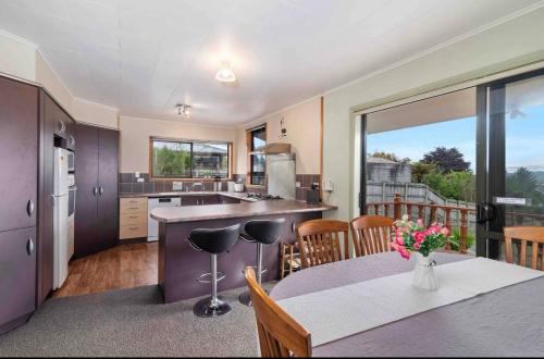 a kitchen and dining room with a table and chairs at Mountain Top kiwi star holiday home in Rotorua