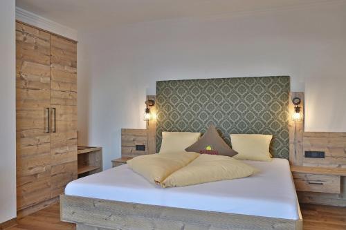 a bedroom with a large white bed with a headboard at Ferien Bauernhof Maurachhof in Sankt Johann im Pongau
