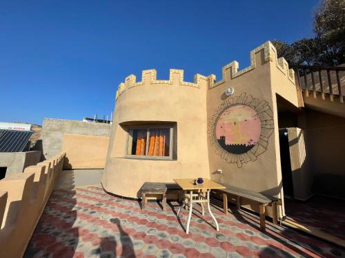 a building with a table and chairs on a patio at Auberge Chez Hassan in Imsouane