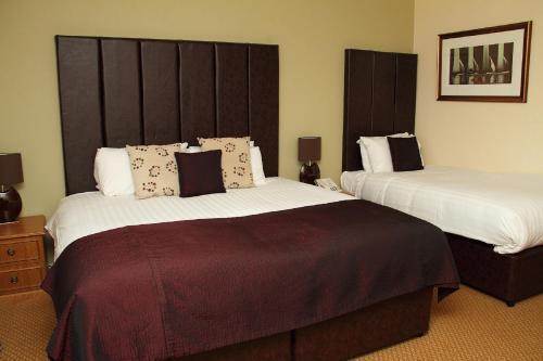 a hotel room with two beds in a room at Abbey Hotel Golf & Spa in Redditch