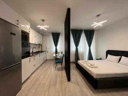 a small bedroom with a bed and a kitchen at Perfect Host Palas in Iaşi