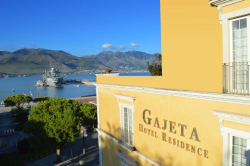 a yellow building with a boat in the water at Hotel Gajeta in Gaeta
