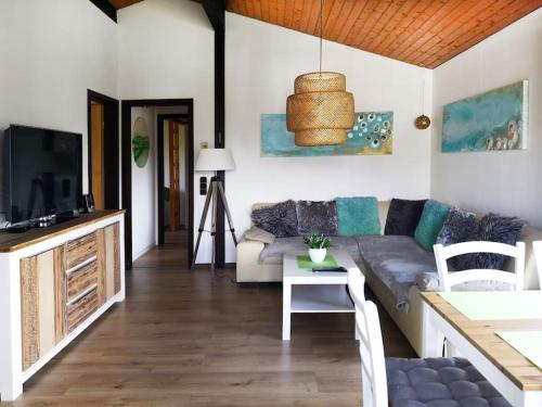 a living room with a couch and a table at Ferienhaus LENA im Sauerland direkt am Hennesee in Meschede