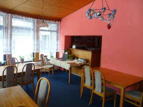 ハルラホフにあるV+V Pensionのピンクの壁のダイニングルーム(木製のテーブルと椅子付)