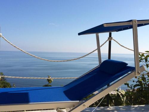 une chaise bleue assise sur le côté de la plage dans l'établissement Blue Island Villa Caterina, à Casteldaccia