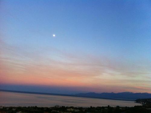 Ein Mond im Himmel über einem Wasserkörper in der Unterkunft Blue Island Villa Caterina in Casteldaccia