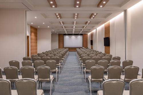a conference room with rows of chairs and a screen at Hyatt Regency Lisbon in Lisbon