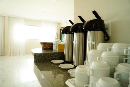 a kitchen with white cups and pitchers on a counter at Pousada Marítimos in Maragogi
