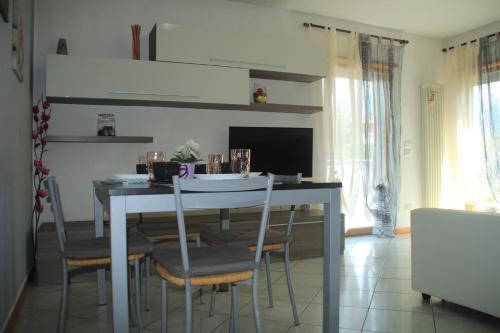 a kitchen with a table with chairs and a television at Casa Vela in Riva del Garda
