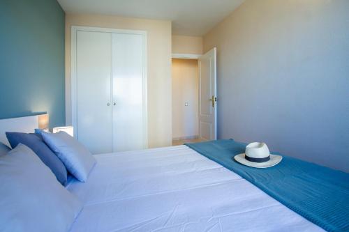 a white bed with a hat on top of it at ESPACIO 5 - Primera Línea de Playa in Cullera